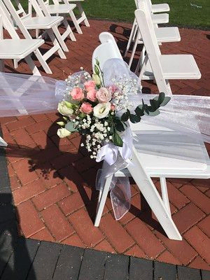 Flowers attached to a chair at warwickshire outdoor ceremony